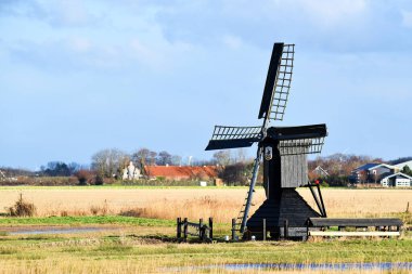 Callantsoog, Hollanda. Ocak 2023. Callantsoog yakınlarındaki çayırlarda küçük bir rüzgar türbini. Yüksek kalite fotoğraf
