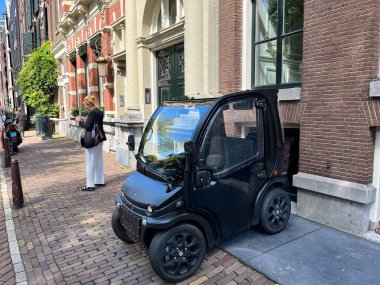 Amsterdam, Hollanda. 11 Ağustos 2023 Büyük bir şehirde sokakta küçük elektrikli arabalar. Yüksek kalite fotoğraf