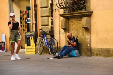 Pisa, İtalya. 16 Eylül 2023. Pisa sokaklarında bir dilenci. Yüksek kalite fotoğraf