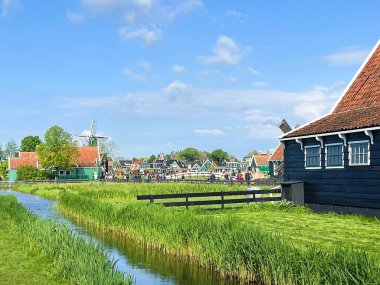Zaandam, Hollanda. 30 Nisan 2024. Zaanse Schans 'taki turistler. Tipik Hollandalı: tahta ayakkabılar, laleler ve yel değirmenleri. Yüksek kalite fotoğraf