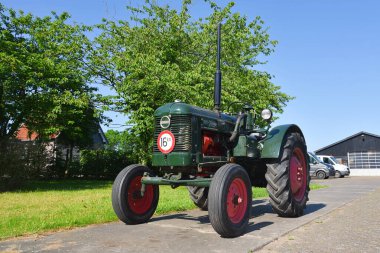 Westerland, the Netherlands. June 3, 2024. An old restored tractor in the yard of a farm. High quality photo clipart
