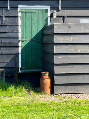 Zaanse Schans, Hollanda. 11 Mayıs 2024. Zaanse Schans 'taki eski bir ahırın önünde eski süt kutuları. Yüksek kalite fotoğraf