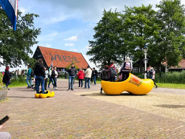 stock image Zaandam, the netherlands. july 14, 2024. Tourists fitting a huge wooden shoe at the Zaanse Schand. High quality photo