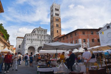 Lucca, İtalya. 16 Eylül 2024 Lucca katedralinden önce pazar yerindeki bit pazarı. Yüksek kalite fotoğraf