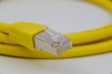 Den Helder, Hollanda. 14 Aralık 2024. Beyaz bir arkaplanda sarı bir ethernet kablosu yakın plan. Yüksek kalite fotoğraf