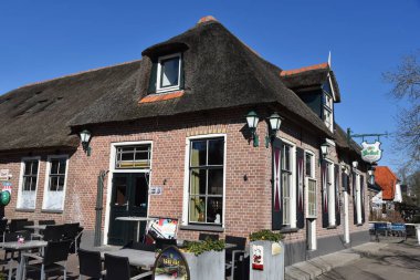 Giethoorn, Hollanda. 19 Mart 2025. Giethoorn 'un merkezinde sazdan çatıları olan eski çiftlik evleri. The Fanfare, Bert Haanstra 'nın filmindeki ünlü kafe. Yüksek kalite fotoğraf