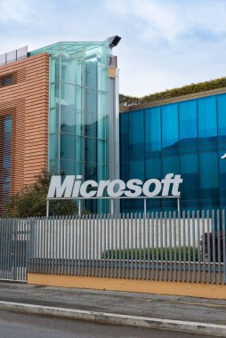 Microsoft logosu. Microsoft merkezi Roma, İtalya 'da. Bilgisayar yazılımı ve bulut şirketi, ofis binası arka planda