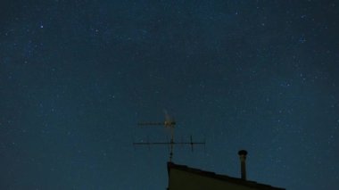 Yıldızlı bir gece, yıldızlarla geçen zaman ve Samanyolu çatı anten ve baca üzerinde.
