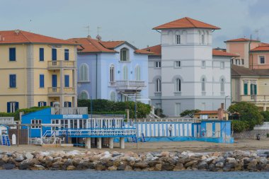 Akdeniz sahilinde canlı binaları olan manzaralı kıyı mimarisi. San Vincenzo, Livorno, İtalya