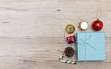 Noel kümesi yüksek açılı hediye kutuları kırsal ahşap zeminde sunuluyor. Hediyeler çerçevenin kenarlarına dağılır, nesneniz veya kopyanız için ortada bir boşluk bırakır.