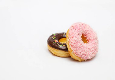 Beyaz arka planda izole edilmiş pembe çörekler ve çikolatalar..