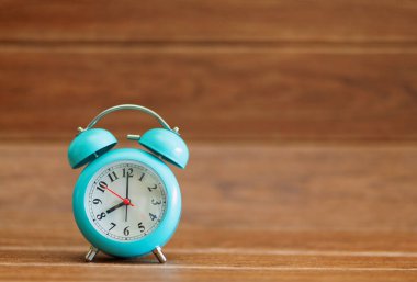 çalar saat ahşap arka plan üzerinde.