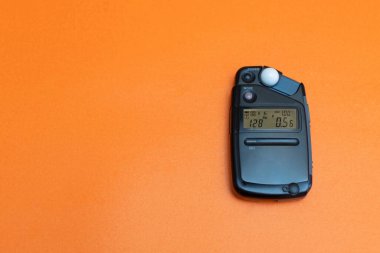 light meter for photography on the orange background copy space clipart