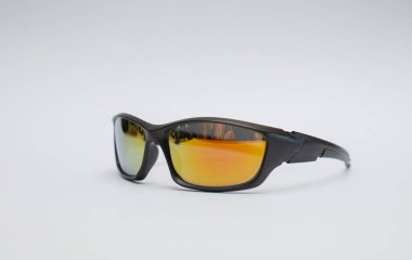 Beyaz arka planda izole edilmiş sarı-turuncu cam mercekli siyah güneş gözlükleri..