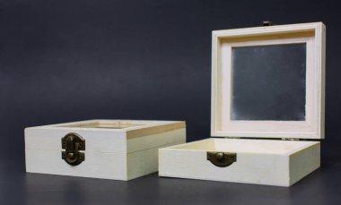 Boş küçük, açık kahverengi tahta kutu konteynır nesneleri siyah arka plan yuvalarında ayrı mandallarla kilitlenir. Küçük el sanatları, çantalar, dekorasyonlar, gizli çantalar.