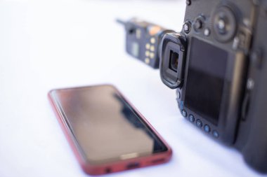 Telefon ve kamera birbirine yakın, arka plan beyaz..