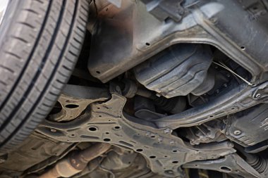 image of the underside of the car being lifted with a jack to check the condition of maintenance for safety according to use