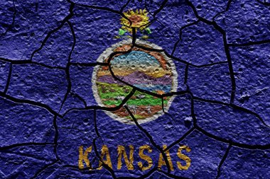 Kansas state flag of United States on a mud texture of dry crack on the ground