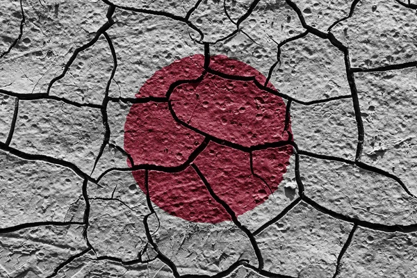 Japan flag on a mud texture of dry crack on the ground