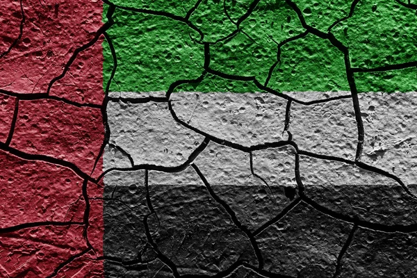 United Arab Emirates flag on a mud texture of dry crack on the ground