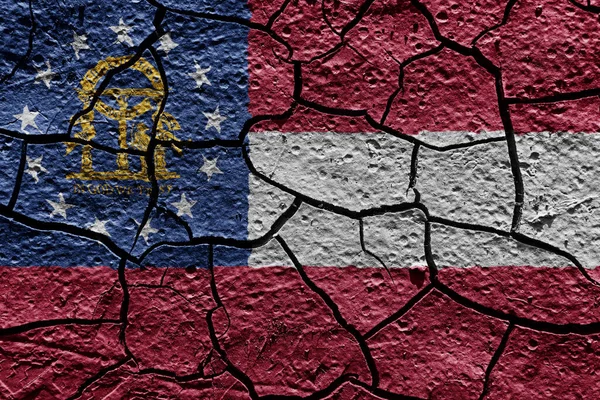 Georgia state flag of United States on a mud texture of dry crack on the ground