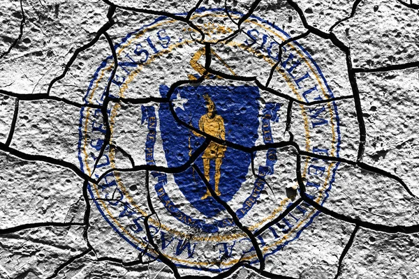 Massachusetts state Seal flag of United States on a mud texture of dry crack on the ground