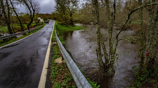 一条山路的桥 它拯救了一条因雨水而涨得很厉害的小河 — 图库照片