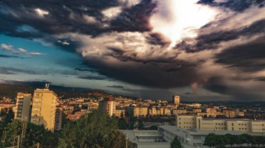 Gün batımında bir şehirde fırtına bulutları açık renk için göze çarpar