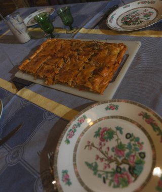 Çiçekli tabakları ve içki bardaklarını görebileceğiniz bir masanın ortasına.