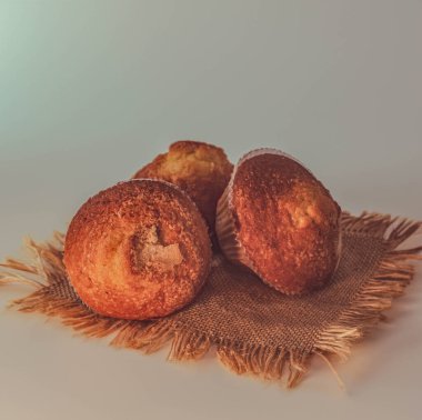 Pişmiş kek, mavimsi bir arka planda, kırsal bir peçeteye yerleştirilmiş.