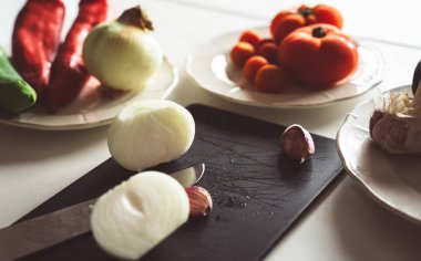 Tahtada bıçakla doğranmış bazı sebze malzemeleri pişirmek için.