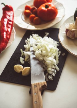 Tahtada bıçakla doğranmış bazı sebze malzemeleri pişirmek için.