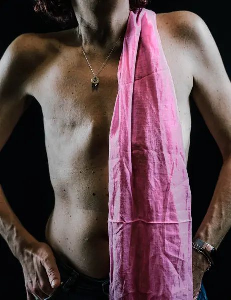 Sağ göğsündeki kanserin yol açtığı yara izini gösteren ve kendini pembe bir eşarpla kapatan bir kadının gövdesi.