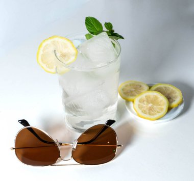 Güneş gözlüklü ve limonlu sıvının düşük sıcaklığı nedeniyle camı buğulandıran su dolu bardaklar.