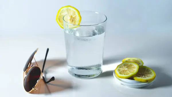 Güneş gözlüklü ve limonlu sıvının düşük sıcaklığı nedeniyle camı buğulandıran su dolu bardaklar.