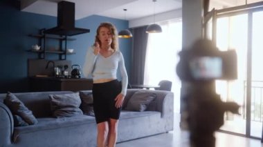 Sosyal medya platformunda beğeniler ve takipçiler için moda dans yarışması videosu kaydeden pozitif kız. Komik dans eden bir kadın, bir evdeki oturma odasında öyküler için gösterisini filme alır.