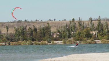 Kiteboardcu, Sea Bay 'de uçurtmaya biniyor. Uçurtma sörfü alanında serbest stil mutant eğitimi. Uçurtmacı eğleniyor. Aşırı su sporları.