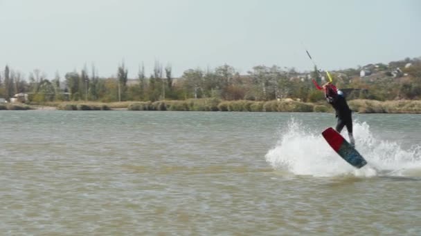 Kiteboarder骑在风筝上 在海湾里做着练习技巧 自由式风筝跳跃 在池塘冲浪点进行训练 Kitesurfer喜欢骑马极端水上运动 慢动作120 Fps — 图库视频影像