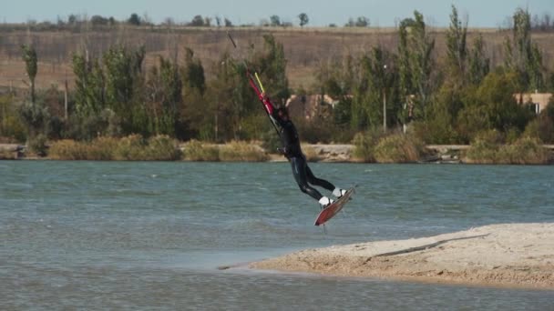 Kiteboarder庞然大物从海滩出发 带着风筝在海湾里做着和练习着戏法 自由式风筝跳跃 在池塘上训练 极端水上运动 慢动作120 Fps — 图库视频影像