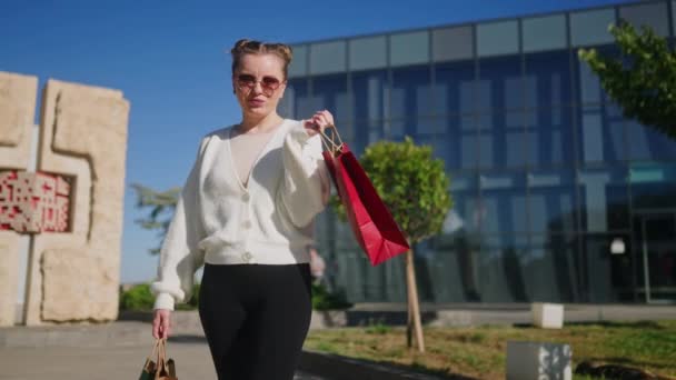 Gelukkige Vrouw Met Boodschappentassen Die Vanuit Het Winkelcentrum Door Stad — Stockvideo