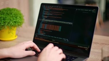 Serbest çalışanların ellerini dizüstü bilgisayarın klavyesinde daktilo koduyla kapat. Kamera geliştiricilerin etrafında slayt yapar parmaklar bilgisayar ekranına bir program kodu yazarlar. Çevrimiçi uygulama veritabanı üzerinde çalışan programcı.