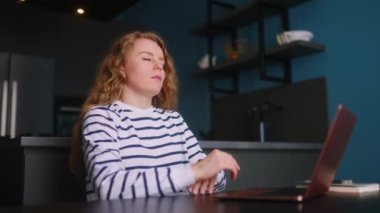 Çok çalışan kadın evde dizüstü bilgisayarla çalışıyor, baş ağrısı çeken şakaklara masaj yapıyor. Bilgisayarı uzaktan çalıştırdıktan sonra yorgun düşmüş bir kadın göz yorgunluğu çekiyor. Görsel yorgunluk ve stres.