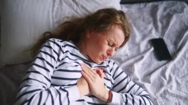 Kafkasyalı bir kadın yatak odasında kalp ağrısı çekiyor. Uyandıktan sonra kendini çok kötü hissediyor. Genç bir kadın göğsünde şiddetli bir ağrı hissediyor. Kız kalp ağrısı çekiyor.