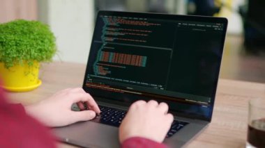 Serbest çalışanların ellerini dizüstü bilgisayarın klavyesinde daktilo koduyla kapat. Kamera geliştiricilerin etrafında slayt yapar parmaklar bilgisayar ekranında program kodunu yavaş çekimde yazar. Bir uygulama üzerinde çalışan programcı.