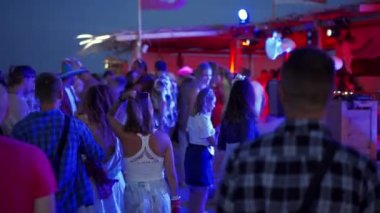 2020-07-25 - Henychensk, Ukraine. Spot Guide Kite Club - Wave Festival. Multi ethnic people in boho outfits dance enjoy open air music fest on sunset by sea. Stylish audience have fun on beach party.
