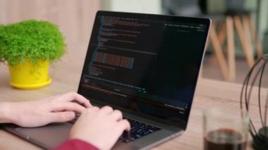 Serbest çalışanların ellerini dizüstü bilgisayarın klavyesinde daktilo koduyla kapat. Kamera geliştiricilerin etrafında slayt yapar parmaklar bilgisayar ekranında program kodunu yavaş çekimde yazar. Bir uygulama üzerinde çalışan programcı.