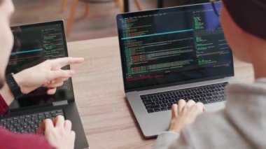 İki hippi iş arkadaşı geniş bir uzay ofisinde dizüstü bilgisayarlarla oturma projesini paylaşıyor. Geliştiriciler uygulama programı kodunu tartışıyor. Kodlayıcı ve yönetici yazılım mimarisine danışır.