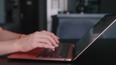 Kameralar kadın serbest çalışanların elleri etrafında kayıyor ve dizüstü bilgisayarda yavaş çekimde klavyeyle yazı yazıyorlar. Ofiste internetle çalışan iş kadını. Evden uzakta çalışan bir kız. Yavaş çekim takip çekimi..