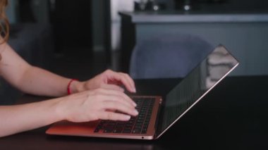 Kameralar kadın serbest çalışanların elleri etrafında kayıyor ve dizüstü bilgisayarda yavaş çekimde klavyeyle yazı yazıyorlar. Ofiste internetle çalışan iş kadını. Evden uzakta çalışan bir kız. Yavaş çekim takip çekimi..