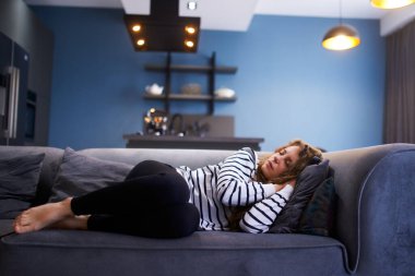 Siesta saatinde kız oturma odasında rahat bir kanepede uyur. Uyuyan kadın gün boyu kanepede kestiriyor..